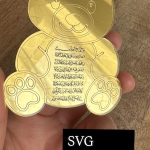 Könnte beinhalten: Eine goldfarbene, bärenförmige digitale Datei mit eingraviertem Text. Der Bär hat Pfotenabdrücke auf seinen Füßen und ein lächelndes Gesicht. Das Bild enthält den Text "SVG DXF Digital file" in einem schwarzen Rechteck.
