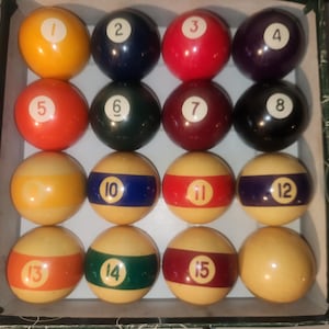 May include: A set of 15 billiard balls in a wooden box. The balls are numbered 1 through 15 and are arranged in a triangle shape. The balls are a variety of colors, including yellow, red, blue, green, and black.