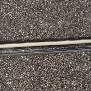 May include: A chrome-finished cake lifter with a red, round handle. The lifter has a long, slender body and a decorative, open-circle design at the end. The lifter is designed to lift and serve cakes and pastries.