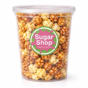 May include: A clear plastic container filled with caramel popcorn. The popcorn is a mix of light and dark brown kernels. A round sticker on the container reads "Sugar Shop CANDY & GIFTS" in pink and green.