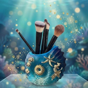 Könnte beinhalten: Ein blau-goldener Make-up-Pinselhalter in Muschelform, gefüllt mit verschiedenen Make-up-Pinseln. Der Halter ist mit goldenen Seesternen, Seepferdchen und Muschelmotiven verziert. Der Hintergrund zeigt eine Unterwasserszene mit Korallen und schimmerndem Licht.