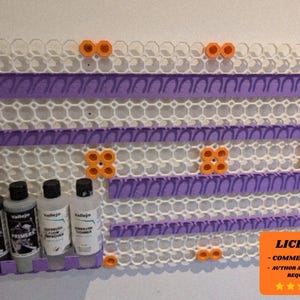 May include: A white and purple wall-mounted paint bottle organizer with orange accents. The organizer has multiple shelves and holds four bottles of paint. The image also includes a license notice.