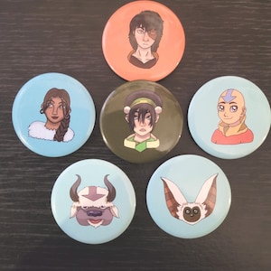 May include: A collection of seven round buttons featuring characters from the animated series Avatar: The Last Airbender. The buttons have illustrations of characters like Zuko, Toph, and Aang, with a light blue, orange, and green color scheme.