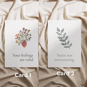 May include: Two white greeting cards with watercolor illustrations and text. Card 1 features a heart with colorful flowers and the text "Your feelings are valid." Card 2 has a leafy branch and the text "You're not overreacting."