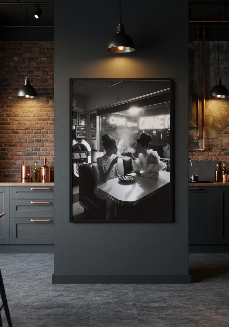 Retro 50s cafe women framed poster hanging in dramatic dark modern kitchen with exposed brick pendant lights copper accents and industrial design aesthetic