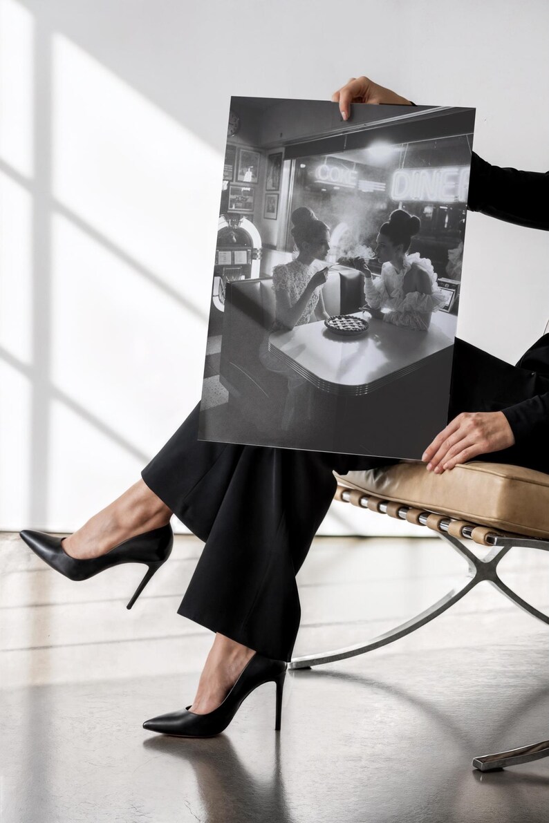 Classic diner neon poster held by woman in black business attire and heels against white wall showing vintage 1950s women at jukebox photography print
