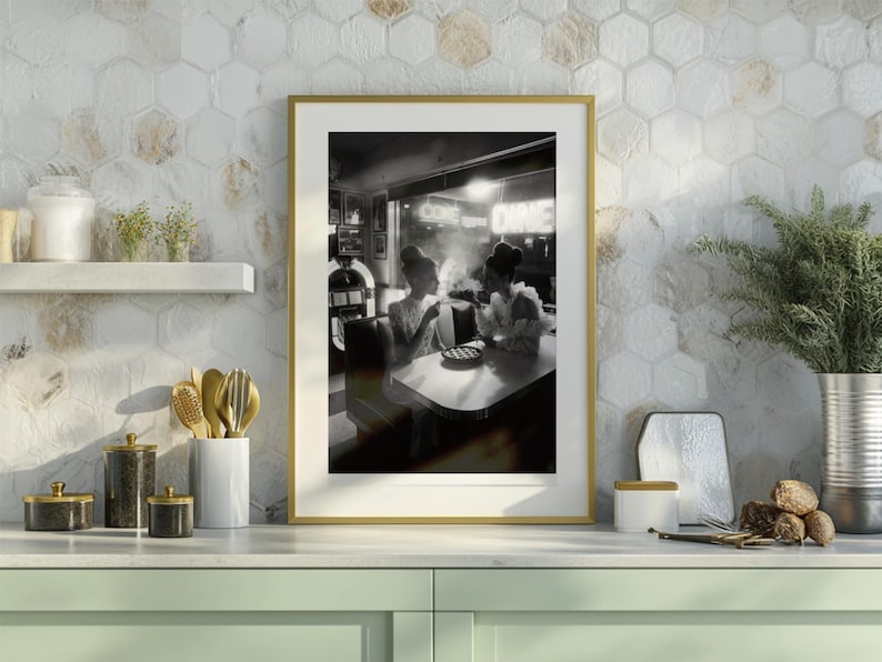 50s diner women jukebox poster in gold brass frame displayed on modern kitchen counter with hexagon tile backsplash sage green cabinets and gold kitchen accessories