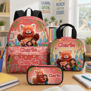 May include: A red backpack, lunch bag, and pencil case set featuring a red panda character, a person, and the name Charlie printed in white. The items are decorated with green bamboo stalks, paw prints, and musical notes against a city skyline.