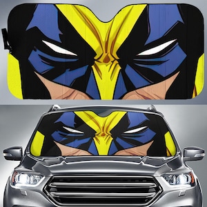 May include: A rectangular car windscreen sunshade featuring a graphic print of a comic book character mask in vibrant yellow, deep blue, and black. The design displays a stylised face with sharp, angular lines and white eye slits across the surface.
