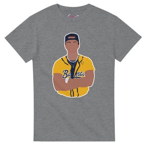Peut inclure: Un t-shirt gris chiné à manches courtes présentant une illustration graphique d'une personne portant une casquette de baseball bleu foncé et un maillot de baseball jaune boutonné avec le mot Bananas écrit en bleu sur la poitrine.