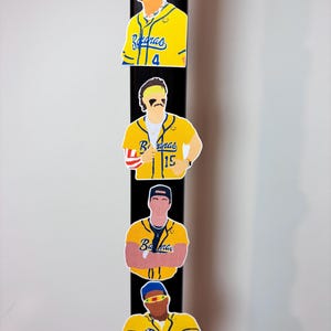 Peut inclure: Quatre autocollants découpés de joueurs de baseball en maillots jaunes avec le mot "Bananas". Les autocollants sont disposés verticalement sur un fond noir. Chaque autocollant présente un joueur différent avec des accessoires uniques.