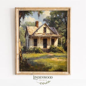 Puede incluir: Una impresión enmarcada de una casa blanca con porche, chimenea y puerta azul oscuro, situada en un exuberante paisaje verde. La obra de arte tiene un estilo vintage y pictórico, con un marco de color claro. La impresión es de Lindenwood Prints.