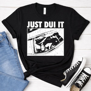 May include: A white ceramic mug with a black handle and the text "But First, Coffee" in a black, bold font. The mug is on a white surface.