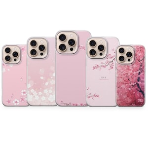 Peut inclure: Cinq coques de téléphone roses avec des motifs de fleurs de cerisier. Les coques présentent divers motifs, notamment des pétales épars, des branches et un arbre complet. Les coques ont un bord transparent autour de la caméra.