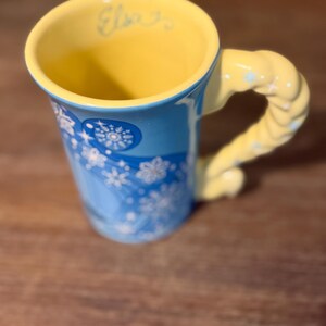 Może przedstawiać: Zestaw trzech ceramicznych kubk&oacute;w z nakrapianym, matowym wykończeniem. Kubki są w odcieniach kremowym, jasnoszarym i ciemnoszarym. Każdy kubek ma prosty, minimalistyczny design i zaokrąglony uchwyt. Do kawy lub herbaty.