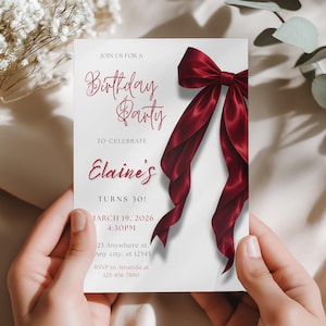 Peut inclure: Une invitation de fête d'anniversaire tenue par des mains. L'invitation est blanche avec du texte bordeaux et un grand ruban bordeaux. Le texte indique "Birthday Party" et "Elaine's Turns 30!" avec la date, l'heure et les informations RSVP.