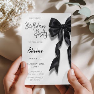 Peut inclure: Invitation de fête d'anniversaire blanche avec un grand nœud noir et des rubans. Le texte indique "Birthday Party" et "Elaine Turns 30!". La date, l'heure et les informations de RSVP sont également incluses. L'invitation est tenue par des mains.