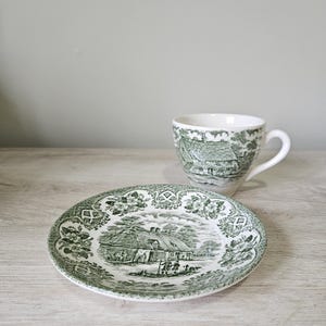 May include: A set of three ceramic mugs with a speckled, matte finish in cream, light grey, and dark grey. Each mug has a simple, modern design and a rounded handle.