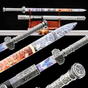 May include: Ornate silver-colored swords with decorative handles and blades. The blades feature colorful artwork with dragons and floral patterns. The swords are displayed on a wooden stand, showcasing their intricate designs and craftsmanship.