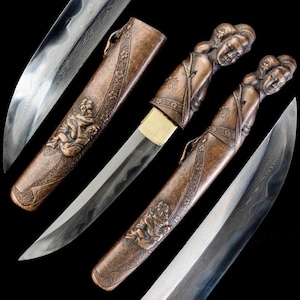 Könnte beinhalten: Ein verzierter japanischer Katana mit einer bronzefarbenen Scheide, die ein detailliertes Relief einer Figur aufweist. Der Griff ist mit einem geformten weiblichen Gesicht versehen. Die Klinge ist sichtbar, mit einem gemusterten Design. Die Gesamtästhetik ist traditionell und künstlerisch.