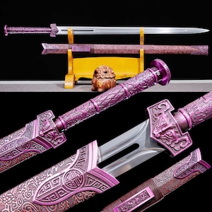May include: A decorative purple sword with intricate carvings and a silver blade. The sword is displayed on a wooden stand, showcasing its ornate handle and scabbard. The design features dragon motifs and geometric patterns.