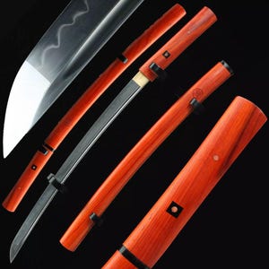 May include: A Japanese katana sword with a polished steel blade and a vibrant red wooden handle and scabbard. The handle and scabbard feature black accents and decorative elements. The blade is partially visible, showcasing its sharp edge.