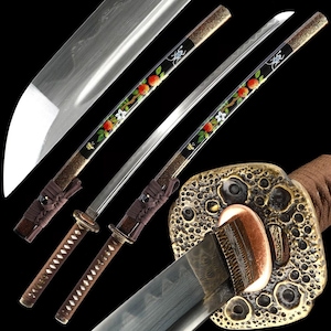 May include: Two Japanese katana swords with ornate handles and blades. The handles are wrapped in brown fabric, and the blades are silver. The scabbards are black with a floral design featuring red fruit and white flowers. The tsuba is gold-colored.