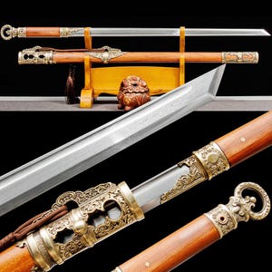 May include: A detailed image of a traditional sword with a wooden handle and scabbard. The blade is silver, and the handle and scabbard are brown with ornate gold-colored metal accents. The sword is displayed on a wooden stand.