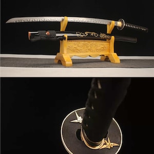 May include: A Japanese katana sword with a silver blade and black handle, displayed on a wooden stand. The scabbard is black with gold accents. The handle features a black wrap and a decorative guard.