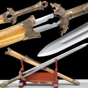 May include: An ornate sword with a polished steel blade and a decorative brass hilt. The wooden scabbard is light brown, and the sword is displayed on a wooden stand. The hilt features intricate dragon-like designs.