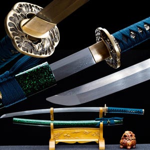 May include: An assortment of Japanese swords, featuring ornate gold-colored tsubas and handles wrapped in blue fabric. The blades have a distinctive pattern. One sword rests in a wooden stand with a green scabbard.