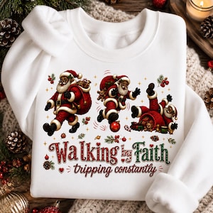Può includere: Una felpa bianca a girocollo con la grafica di tre Babbi Natale neri in abito rosso. Uno cammina, uno corre e uno inciampa su una pallina rossa. Il testo recita Walking by Faith tripping constantly in lettere decorative di colore rosso e verde.