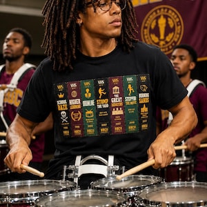 Puede incluir: Una camiseta negra con un estampado gráfico de siete lomos de cintas VHS verticales etiquetados con títulos como School Daze, Higher Learning, Drumline, Stomp the Yard, The Great Debaters, Steppin: The Move y Burning Sands con texto HBCU.