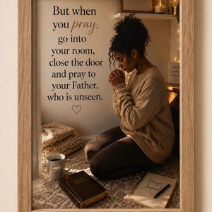 May include: A framed wall art piece featuring the text: But when you pray, go into your room, close the door and pray to your Father, who is unseen. The image shows a person kneeling in prayer with a Bible, a prayer journal, and a mug nearby.