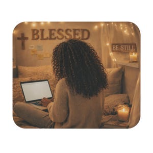 Pode incluir: Uma pessoa com cabelo encaracolado está usando um laptop em uma cama. A palavra "BLESSED" é exibida na parede, junto com uma cruz. As palavras "BE STILL" também são visíveis. A cena é iluminada por luzes de corda e velas.