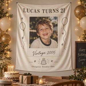 May include: A rectangular fabric wall banner featuring a central photograph of a smiling child. The text reads LUCAS TURNS 21, Vintage 2005, and Chapter Twenty-One. The design includes line-art illustrations of balloons, stars, and a birthday cake.