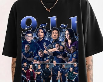 May include: Black crew neck t-shirt with a graphic of the cast from the TV show "9-1-1". The design features the show's title in blue and white, along with images of the actors and actresses. The shirt is a crew neck.