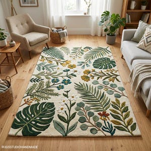 Könnte beinhalten: Rechteckiger Teppich in Creme mit einem botanischen Muster aus grünen, gelben und blauen Blättern und Blumen. Der Teppich liegt auf einem Holzboden in einem Wohnzimmer und schafft eine natürliche, einladende Atmosphäre.