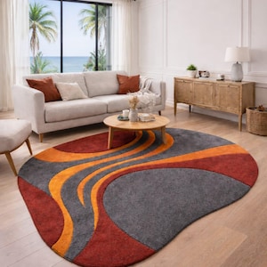 Peut inclure: Un tapis ovale au design moderne. Le tapis présente une palette de couleurs rouge, grise et orange, avec des motifs abstraits et fluides. Le tapis est placé dans un salon.