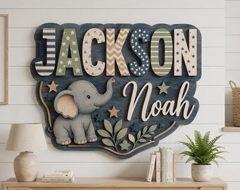 May include: A large, custom-made wooden wall sign featuring the names JACKSON and Noah in layered, multi-colored lettering. The sign includes a cartoon elephant illustration, star accents, and leaf motifs, all set against a dark blue background.