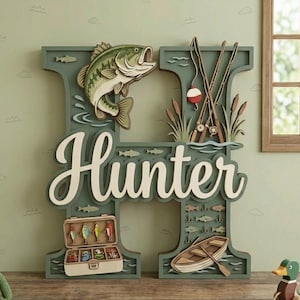 Puede incluir: Una letra H decorativa de madera multicapa en color verde salvia, con un lucio, cañas de pescar, una caja de aparejos y un bote de remos. El nombre Hunter está escrito en cursiva blanca en el centro. El diseño incluye varias siluetas de peces.