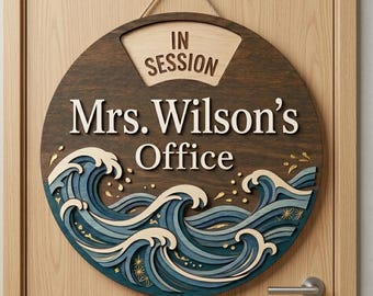 May include: A circular wooden door sign featuring a dark brown background with a layered blue and cream ocean wave design at the bottom. The sign displays the text "IN SESSION" at the top and "Mrs. Wilson's Office" in the center in white lettering.