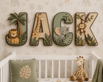 May include: Four large, three-dimensional wooden letters spelling JACK, each featuring layered jungle animal cutouts including a lion, giraffe, elephant, and monkey, accented with palm leaves and vines in shades of sage green, brown, and tan.