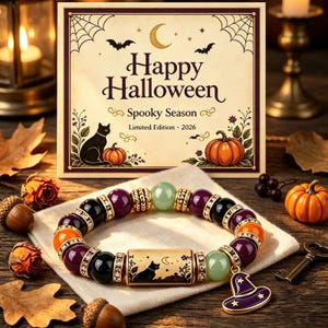 May include: A beaded bracelet featuring alternating black, purple, and light green beads, gold-toned spacers with rhinestones, and a central rectangular gold-toned charm with a black cat silhouette. A purple witch hat charm hangs from the bracelet.