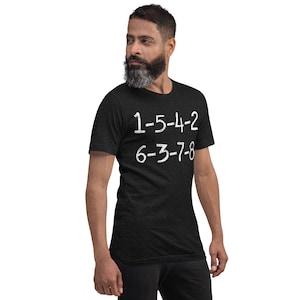 以下が含まれることがあります： 白文字で「1-5-4-2 6-3-7-8」と書かれた黒いTシャツ。