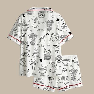 Peut inclure: Ensemble de pyjama blanc avec un imprim&eacute; noir et blanc de lapins et de fleurs. Le haut &agrave; manches courtes et le short ont une bordure rouge. Le mot "HAPPY" est imprim&eacute; sur le short.