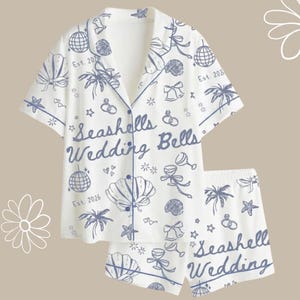 Pijama de satén con conchas y campanas de boda, ideal para despedidas de soltera en la playa.