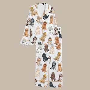 May include: White pajama set with a repeating pattern of various dog breeds in different colors. The long-sleeved top and pants have gold trim. The dogs are wearing crowns and bow ties.