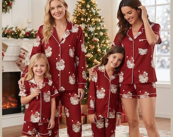 May include: Matching pajama sets in deep red featuring a repeating Santa Claus print with white piping details. The collection includes long-sleeve button-down shirts with matching long pants and short-sleeve button-down shirts with matching shorts.