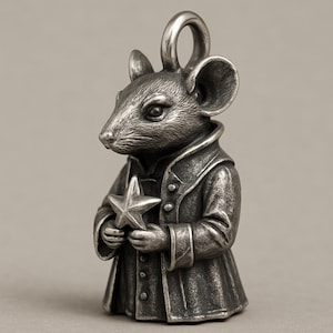 Op de afbeelding: Zilverkleurige hanger in de vorm van een muis die een jas draagt en een ster vasthoudt. De muis heeft grote oren en een lus om op te hangen. De hanger is gedetailleerd met getextureerde oppervlakken.